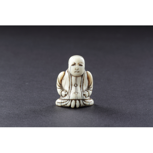 Japanese Ivory Netsuke of a Dutch Merchant Kneeling in his Buttoned Coat and Baggy Trousers